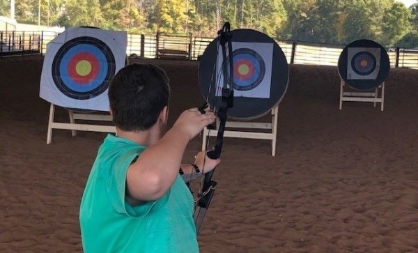 Archer taking aim at target on stand